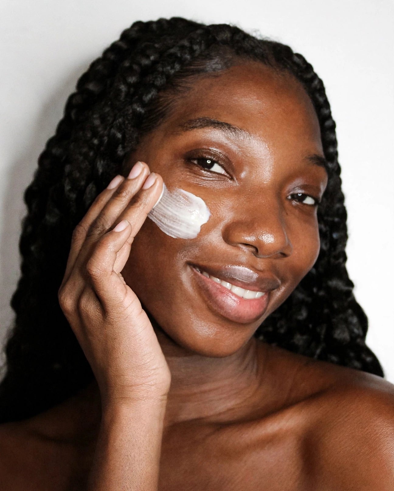 Woman smoothing MelaBODY Face Cream over her cheek